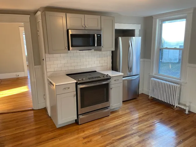 a kitchen with stainless steel appliances a stove a microwave a sink and cabinets