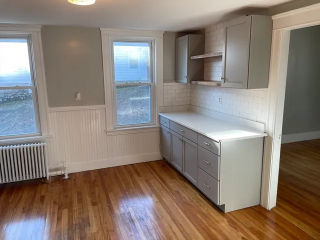 a kitchen with wooden floors and cabinets