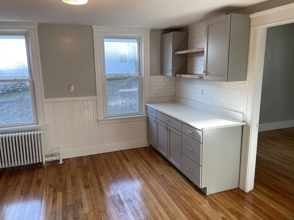 82 Brantwood Road, Unit 2 Worcester, MA 01602 - Photo 3 of 15 a kitchen with wooden floors and cabinets