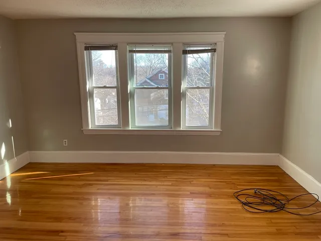 a view of a room with wooden floor and a window