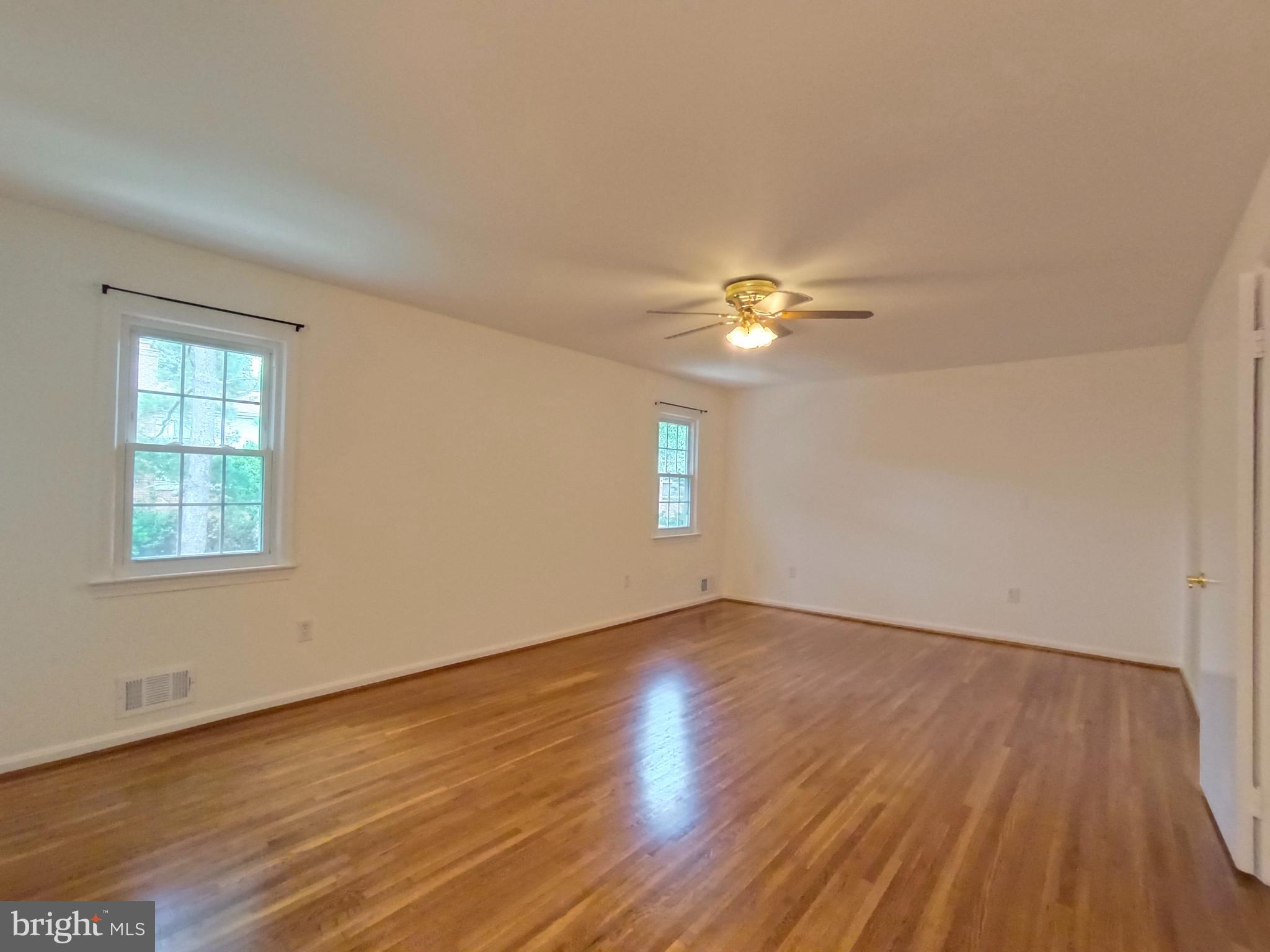 8835 Tuckerman Lane Potomac, MD 20854 - Photo 22 of 46 a view of an empty room with wooden floor and a window