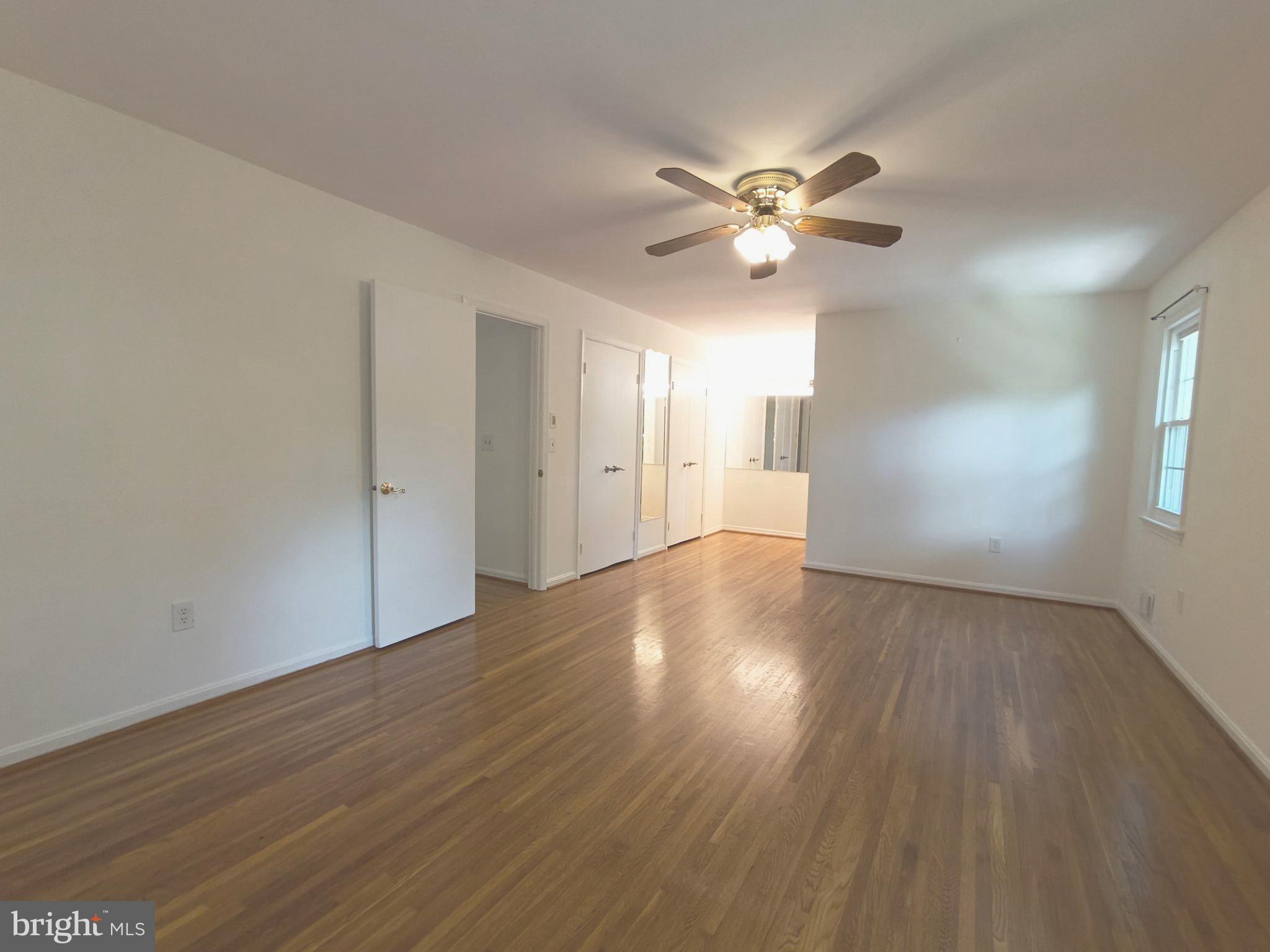 8835 Tuckerman Lane Potomac, MD 20854 - Photo 25 of 46 a view of an empty room with window and wooden floor