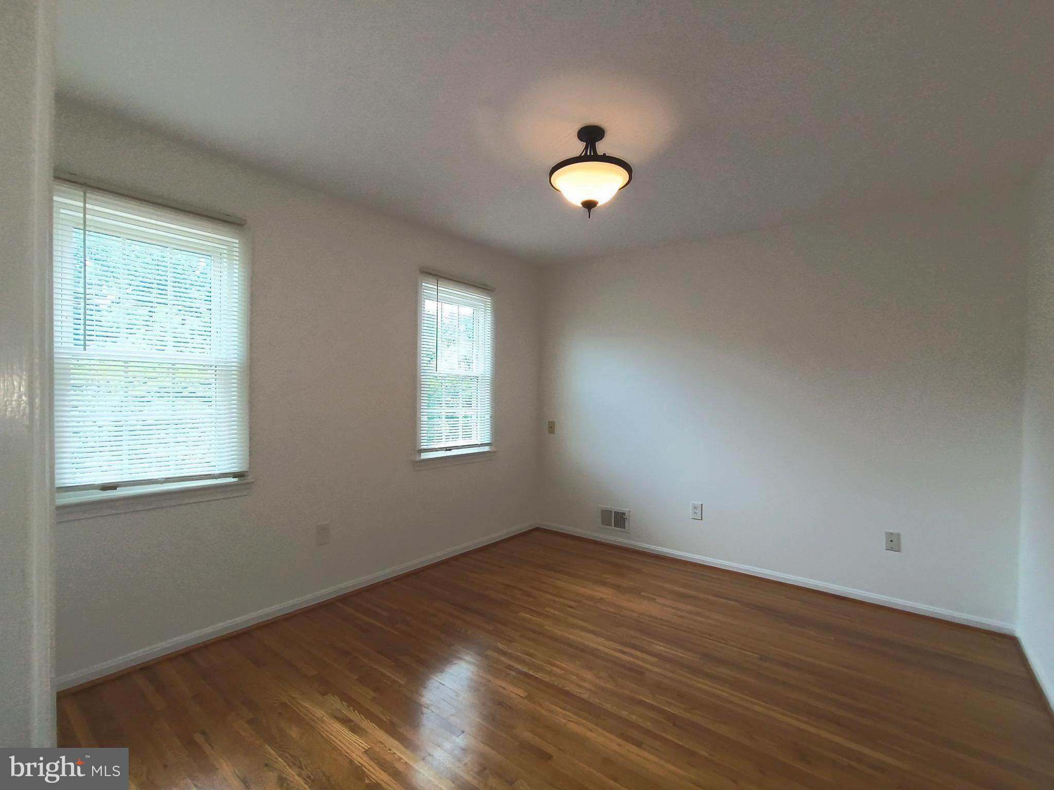 8835 Tuckerman Lane Potomac, MD 20854 - Photo 27 of 46 an empty room with wooden floor and windows