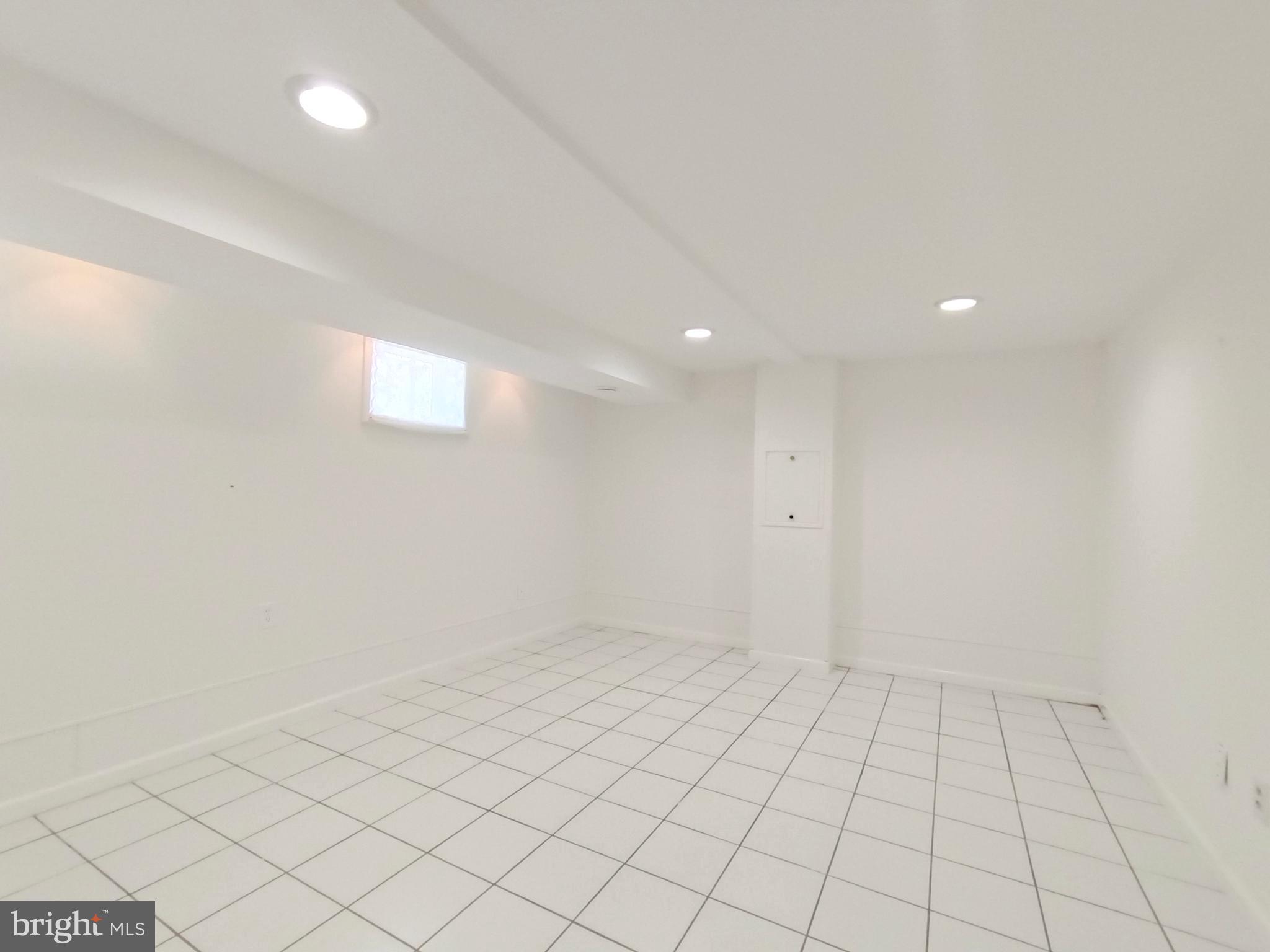 8835 Tuckerman Lane Potomac, MD 20854 - Photo 41 of 46 an empty room with white walls and tiles