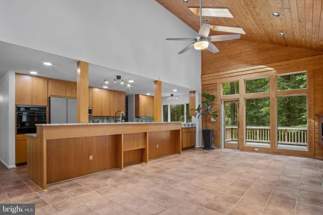 a view of a room with a large window and wooden floor