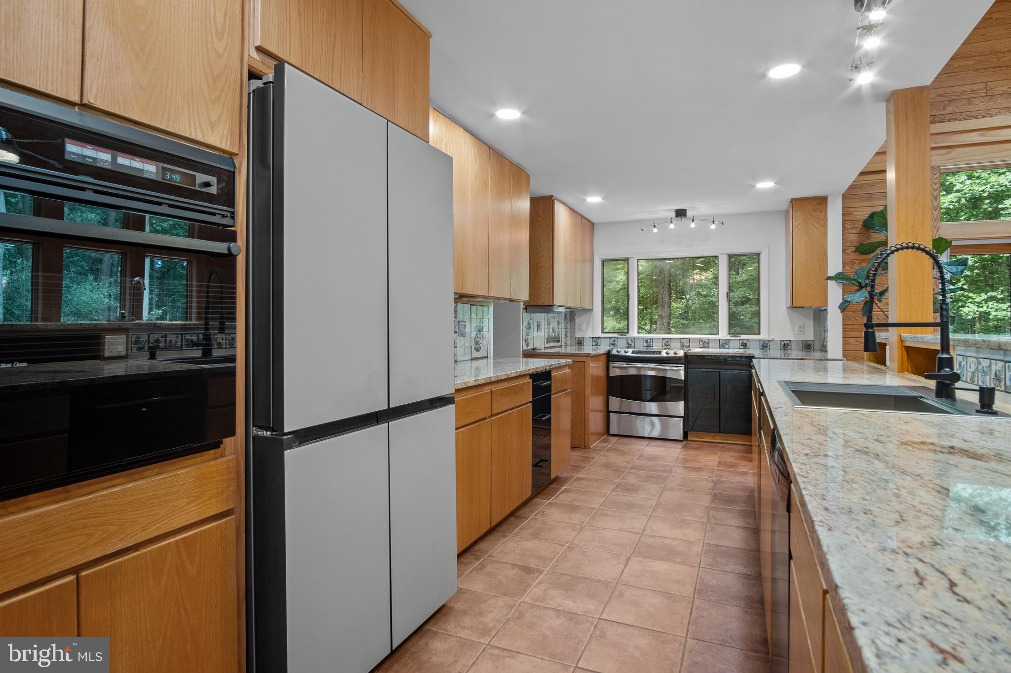 634 Springvale Road Great Falls, VA 22066 - Photo 27 of 67 a kitchen with stainless steel appliances granite countertop a refrigerator and a sink