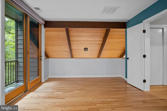 a view of empty room with wooden floor and doors