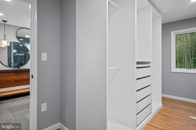 a view of a hallway with closet and wooden floor