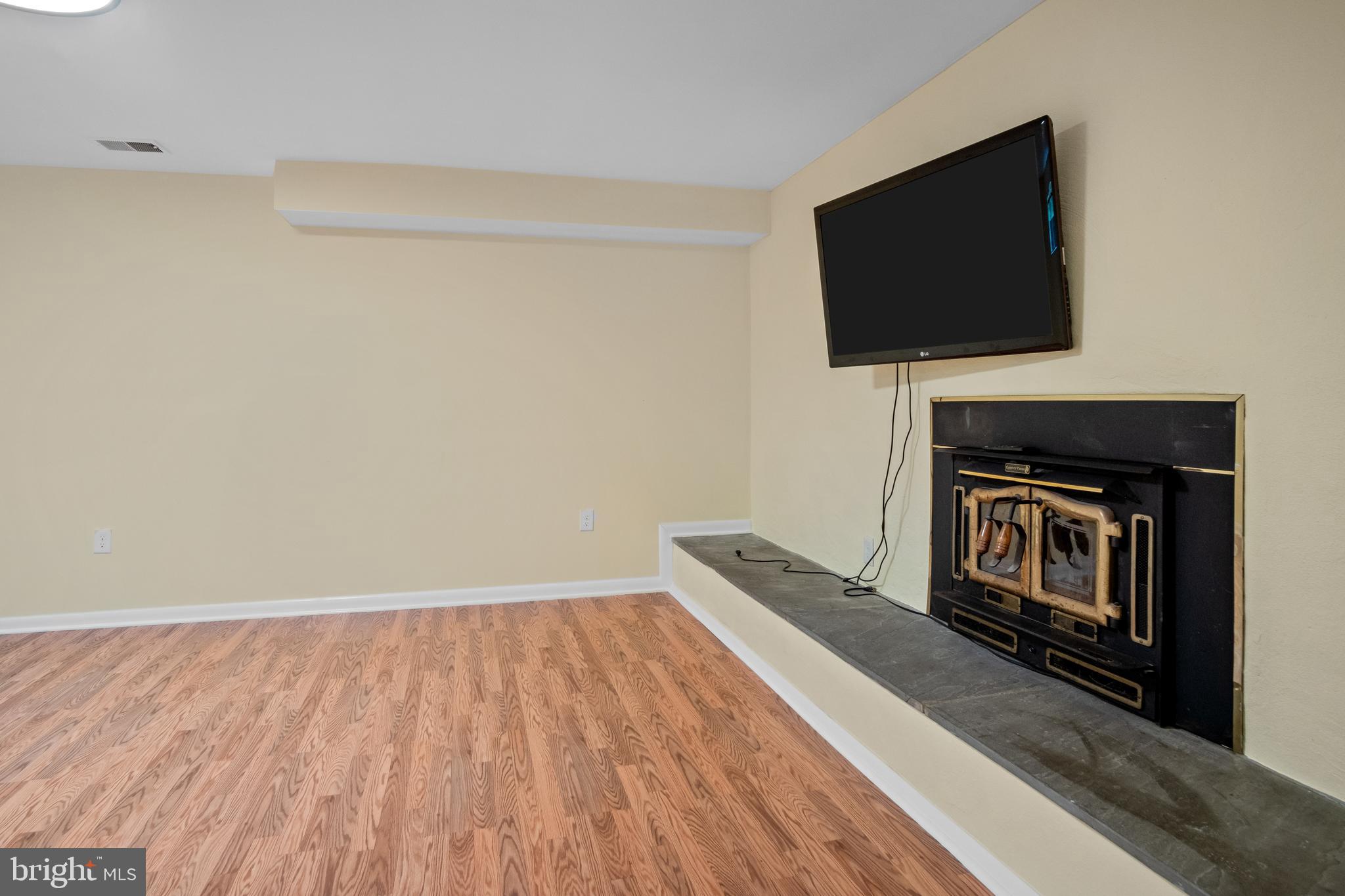 634 Springvale Road Great Falls, VA 22066 - Photo 62 of 67 a living room with a fireplace and a flat screen tv
