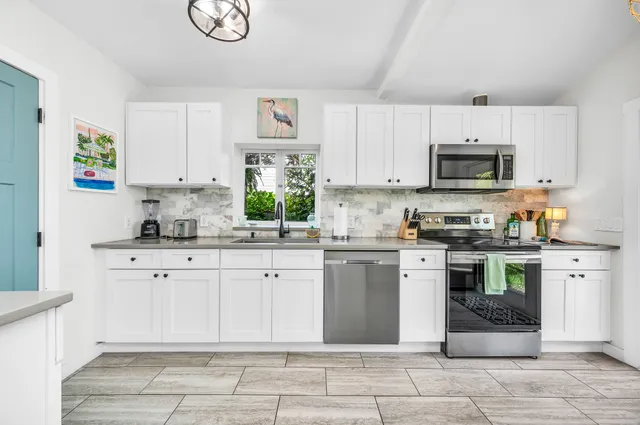 a kitchen with stainless steel appliances granite countertop a refrigerator a sink dishwasher a stove with wooden cabinets and floor