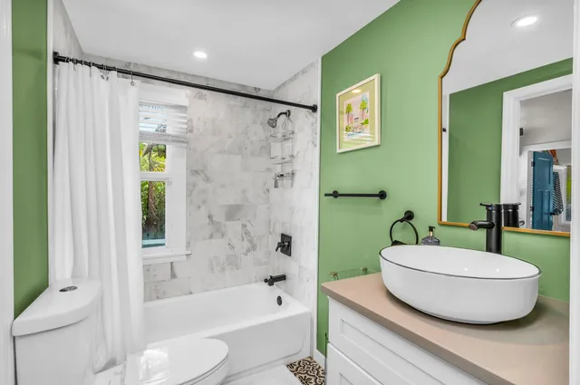 a bathroom with a sink a toilet a mirror and shower