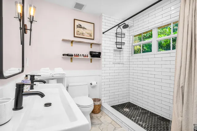 a bathroom with a toilet sink and mirror