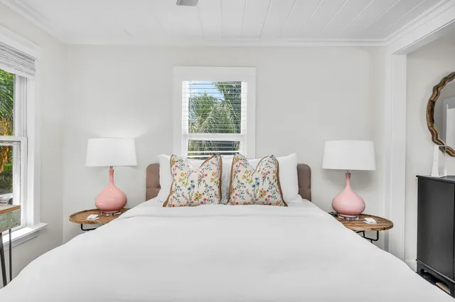 a bedroom with a bed mirror and window