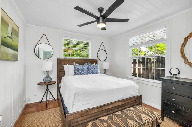 a bedroom with a bed a window and a chandelier