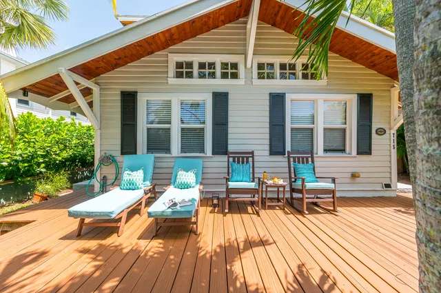 a view of a patio with table and chairs potted plants and large tree