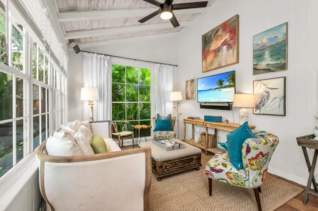 a living room with furniture a flat screen tv and a large window