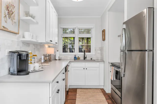 a kitchen with granite countertop a refrigerator stove and sink