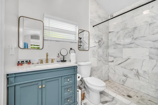 a bedroom with a bed and a large window with chair