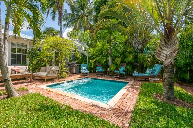 a view of a swimming pool with a patio and a yard