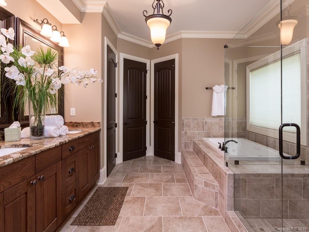 7099 Anchorage Lane Tega Cay, SC 29708 - Photo 15 of 24 a spacious bathroom with a double vanity sink a large mirror and a shower