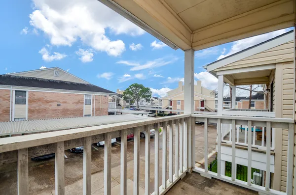 a balcony with wooden floor and fence