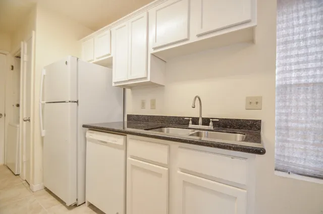 a kitchen with granite countertop a sink and cabinets