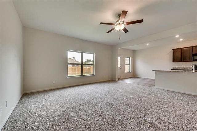 13609 Mineral Road Ponder, TX 76259 - Photo 3 of 21 Spacious living area featuring neutral carpeting, a contemporary ceiling fan, and a large window