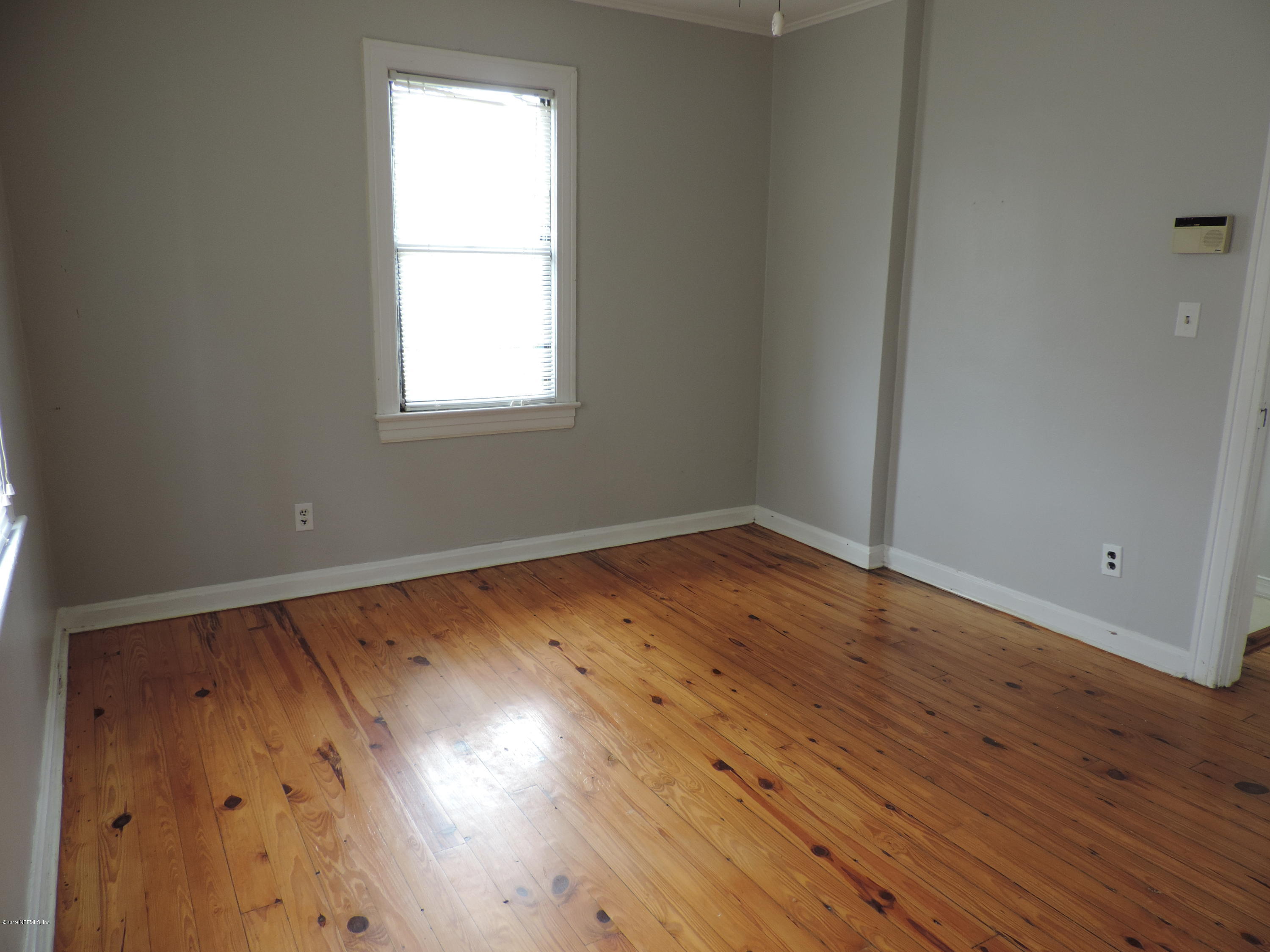 4244 Muncy Road Jacksonville, FL 32207 - Photo 15 of 19 an empty room with wooden floor and windows