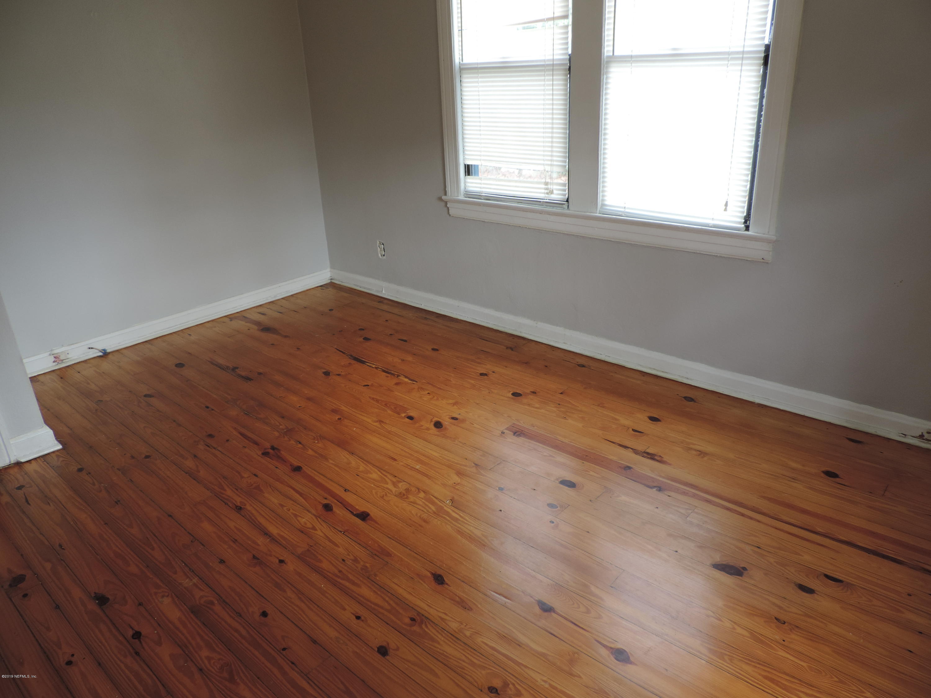 4244 Muncy Road Jacksonville, FL 32207 - Photo 16 of 19 an empty room with wooden floor and windows