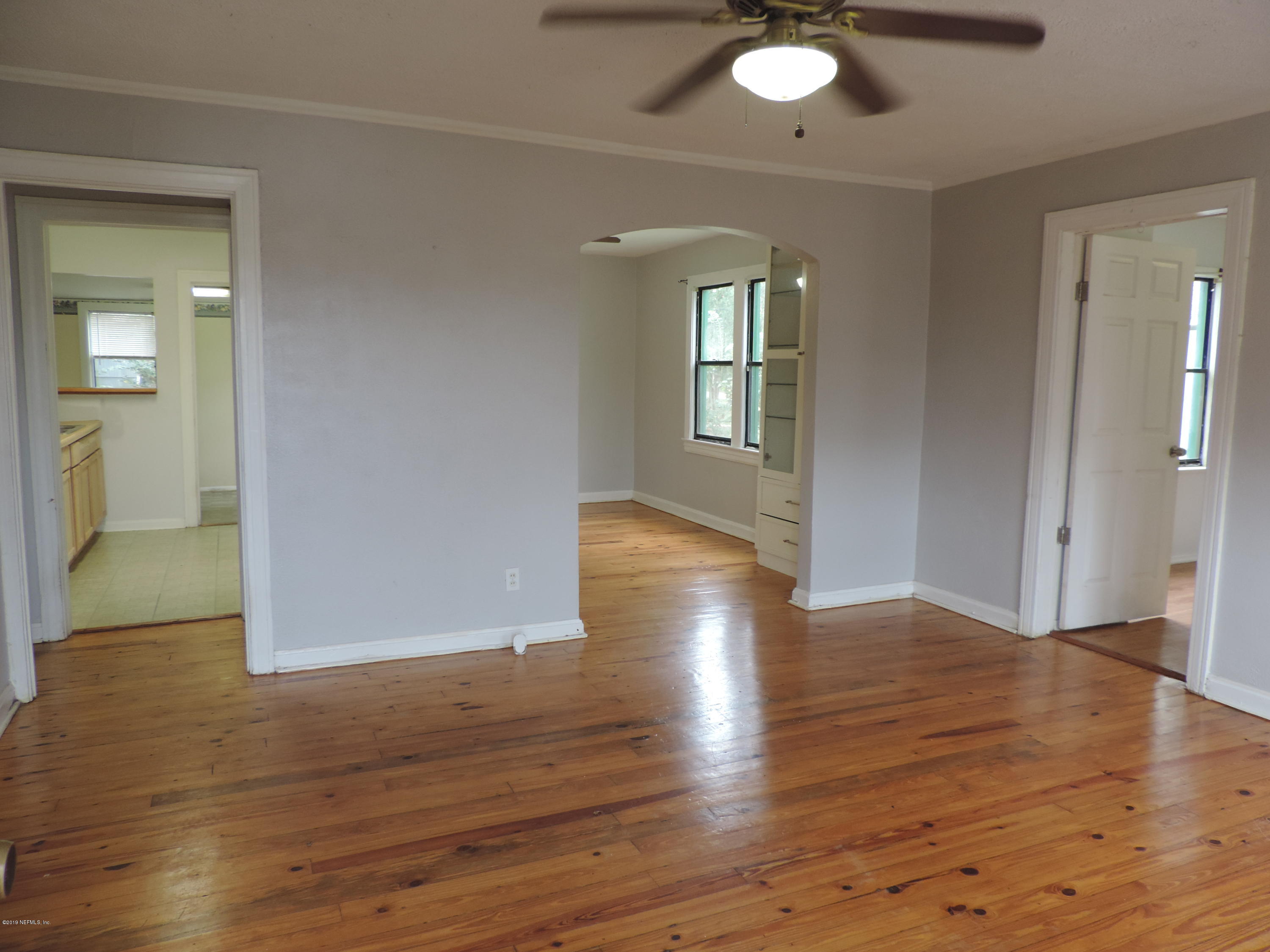 4244 Muncy Road Jacksonville, FL 32207 - Photo 4 of 19 an empty room with wooden floor and windows