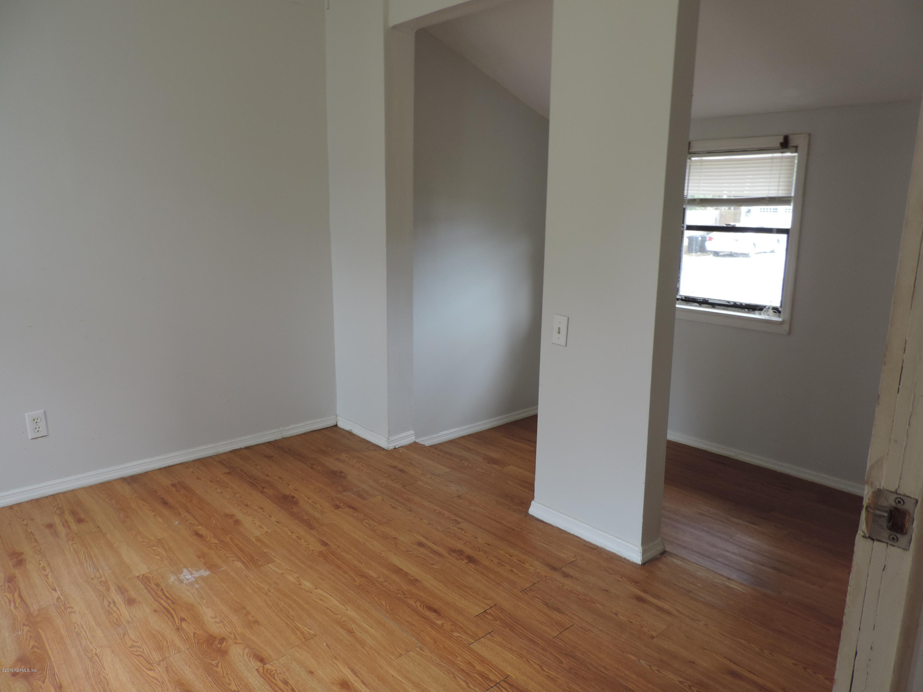 4244 Muncy Road Jacksonville, FL 32207 - Photo 5 of 19 an empty room with wooden floor and windows