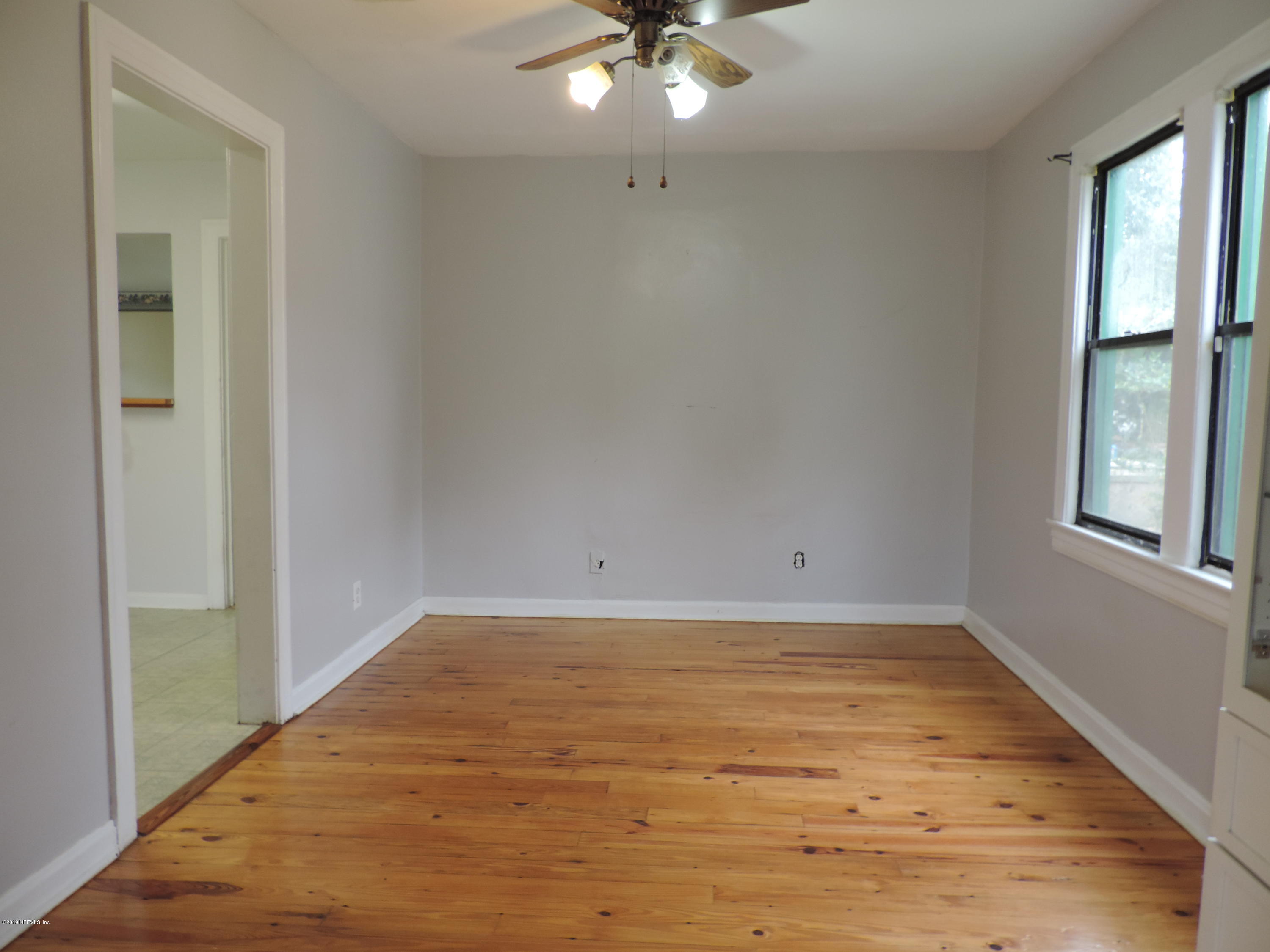 4244 Muncy Road Jacksonville, FL 32207 - Photo 6 of 19 wooden floor in an empty room with a window