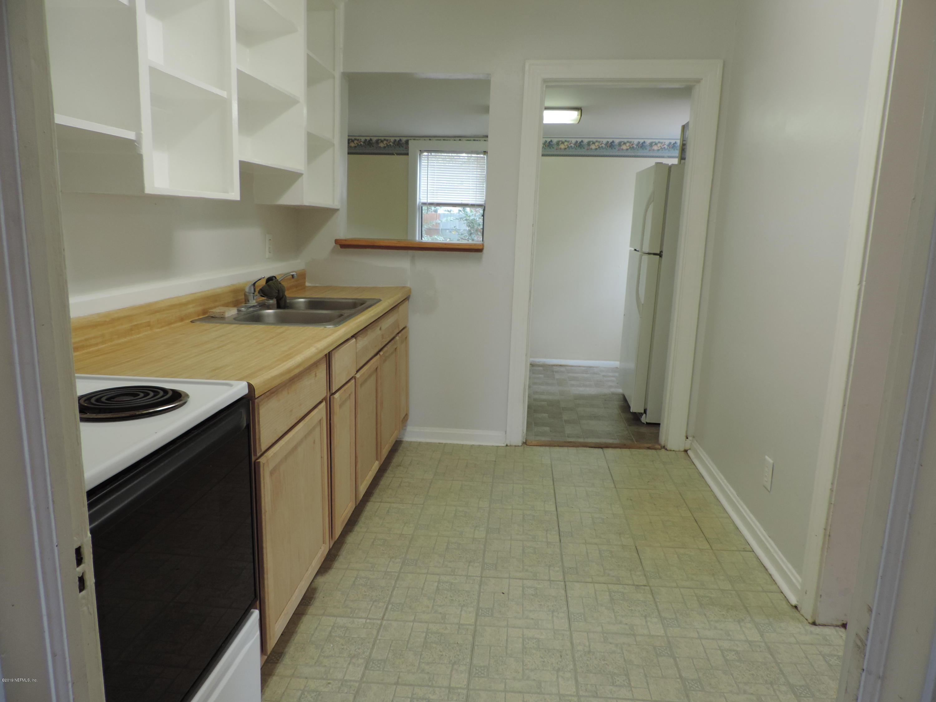4244 Muncy Road Jacksonville, FL 32207 - Photo 9 of 19 a kitchen with a sink stove and cabinets