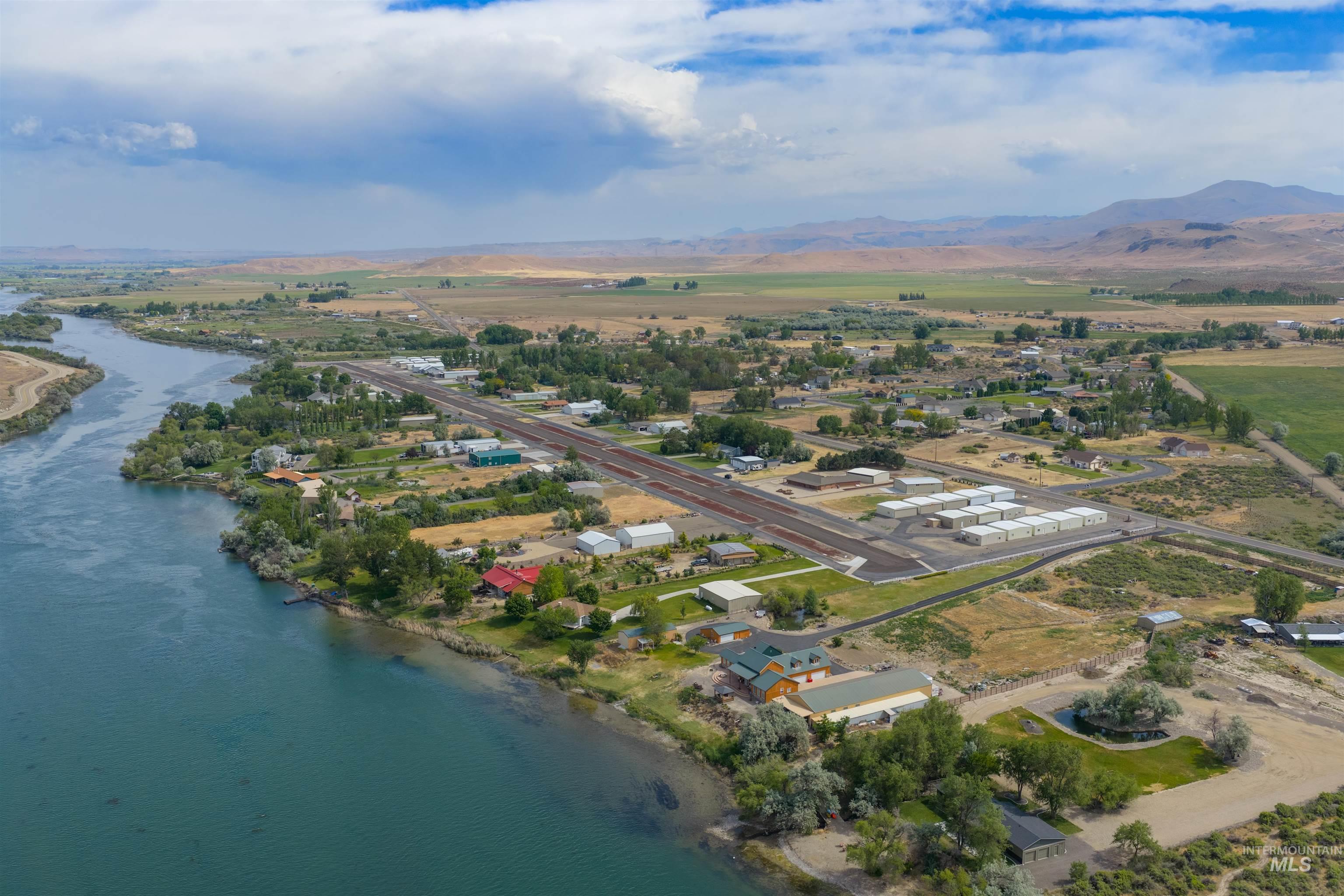 10514 Airpark Loop Road Melba, ID 83641 - Photo 6 of 47 Expansive aerial landscape featuring a prominent river, a community of structures, and distant mountains