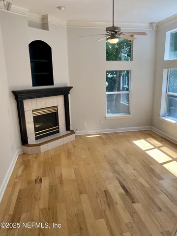 an empty room with windows and fireplace