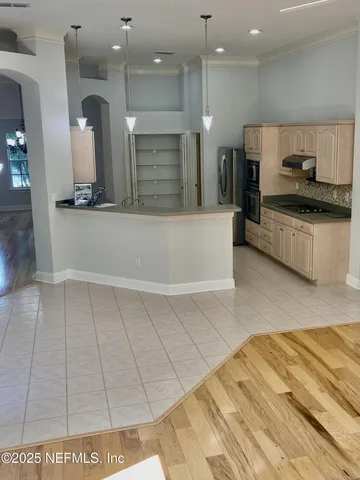 a large white kitchen with a sink and a stove top oven