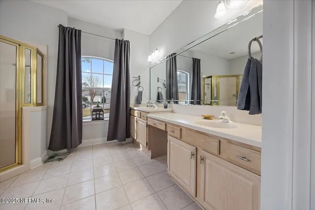 a bathroom with a double vanity sink mirror and bathtub
