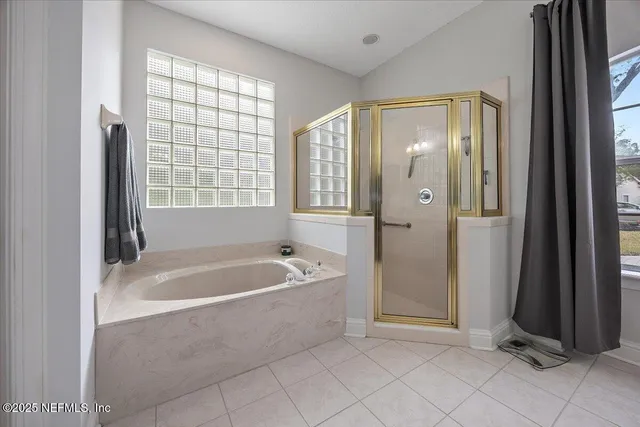 a spacious bathroom with a bathtub and a shower