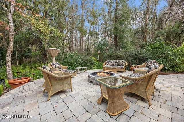 a view of a patio with a dining table and chairs with a fire pit
