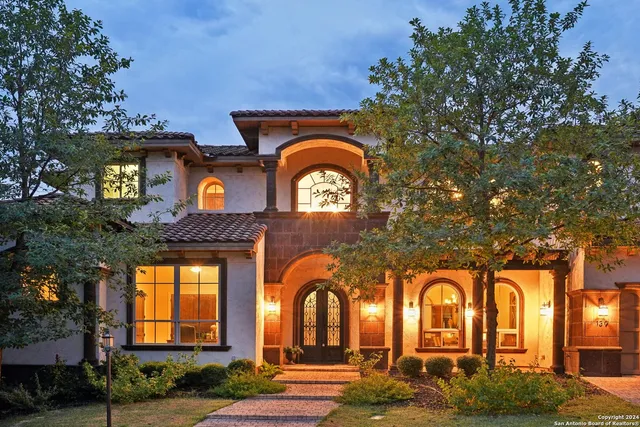 a view of a brick house with large windows and a outdoor space
