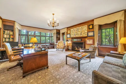 a living room with furniture a fireplace and a chandelier