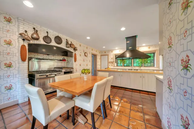 a kitchen with stainless steel appliances kitchen island granite countertop a refrigerator and a stove top oven