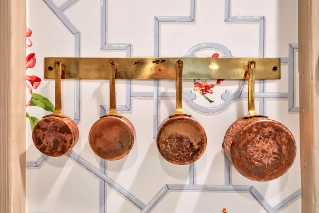 a dining room with wooden floor a chandelier a wooden table and chairs