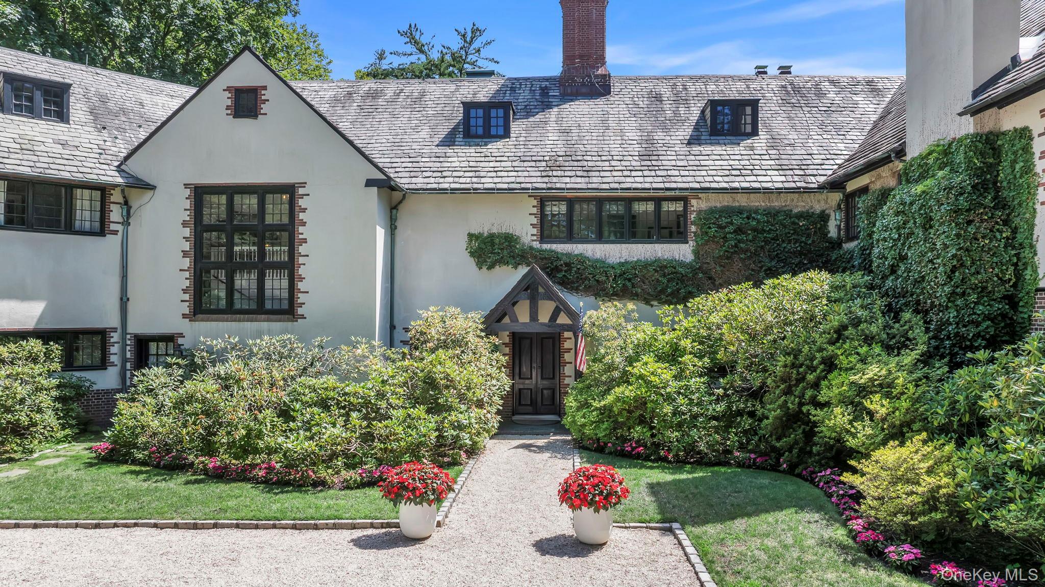 95 Piping Rock Road Locust Valley, NY 11560 - Photo 7 of 42 a front view of a house with a yard