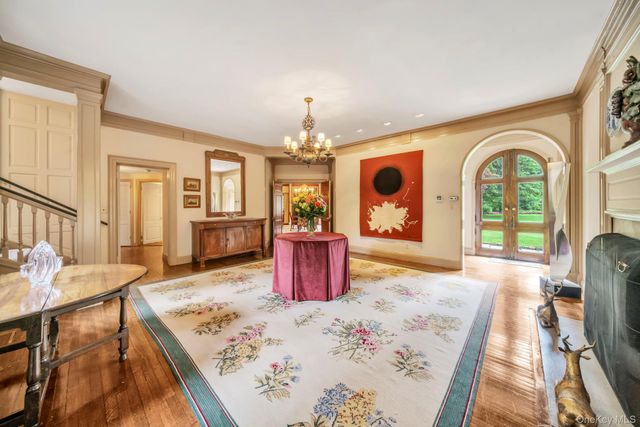 a dining room with wooden floor and chandelier