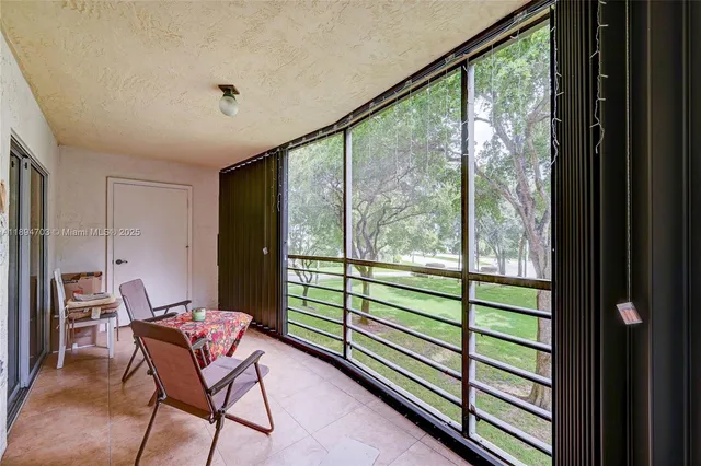 a view of a room with a large window and furniture