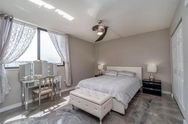 a spacious bedroom with a bed a table and chairs