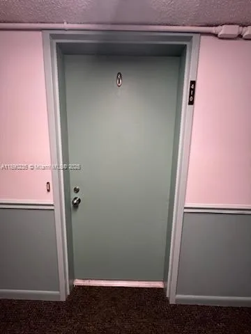 a view of a fountain in front of a big yard with plants