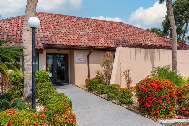 a view of a house next to a big yard and large trees