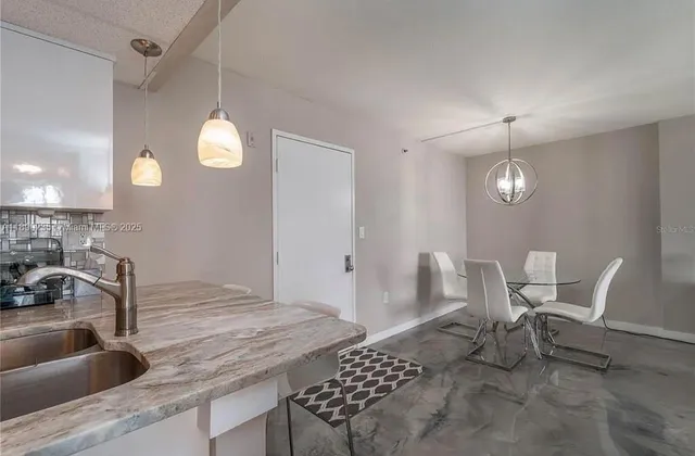 a kitchen with a table chairs and a wooden floor